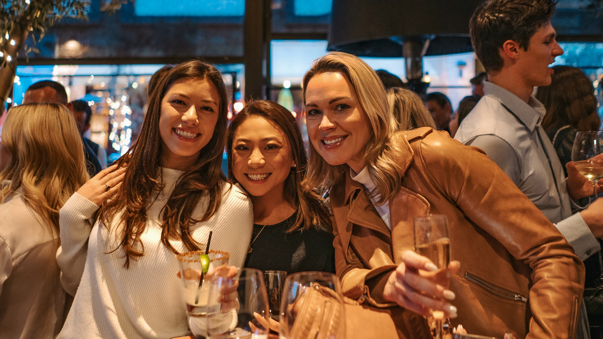 Three ladies smiling at First Fridays CRC gathering.